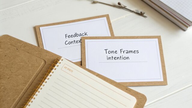 Cards with text feedback and tone on a notepad, workspace with natural light, organized study materials, creative process in action, education setting