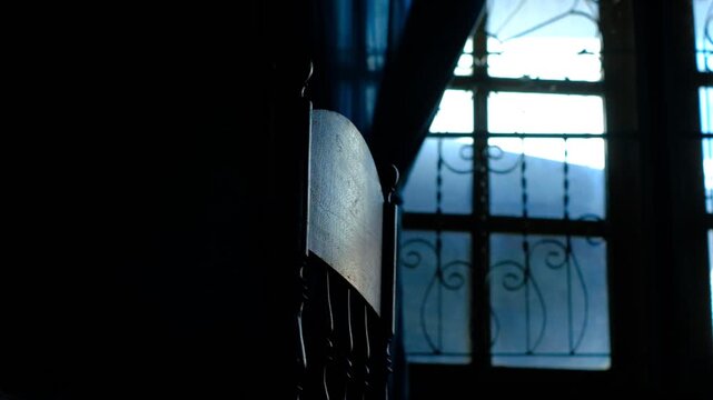 Loniness people scene :Dark chair stands inside 
empty room near ornate window