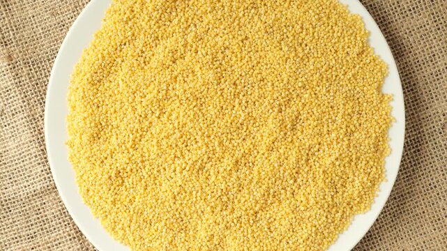 Raw millet grain rotating on a plate