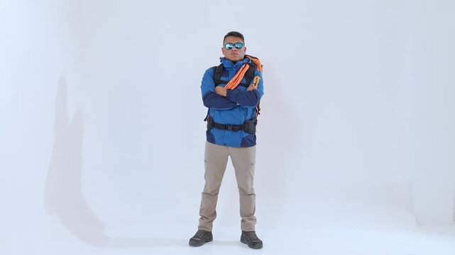 Determined latino mountaineer crossing arms on white background