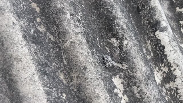 Old corrugated asbestos roof texture with small nail hole