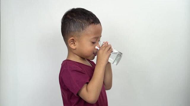 A mother is giving a glass of water to her thirsty son.
