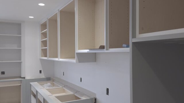 Modern Kitchen Cabinets Installation in Progress, Unfinished Light Wood and Gray Cabinetry