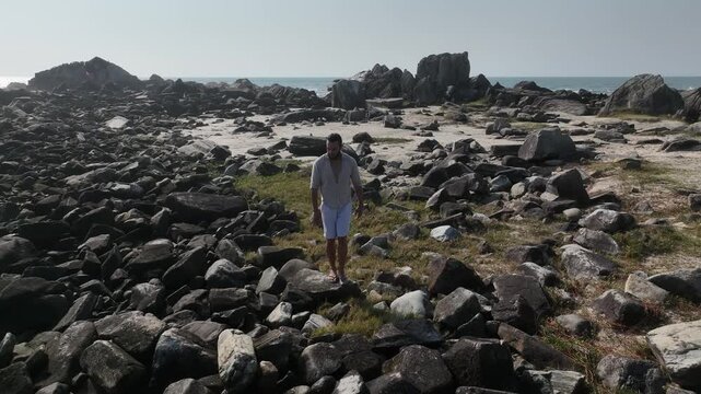 Ponta das Campanhas, Armacao in Florianopolis. A man walks across the island among the rocks. Aerial view 