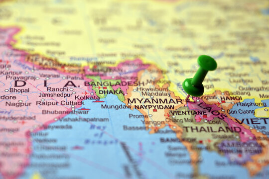 Green Push Pin Marking Myanmar on Paper World Map Macro Close Up with Blurred Background