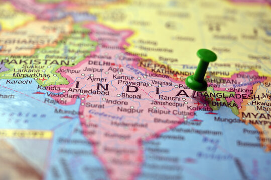 Green Push Pin Highlighting India on Detailed Paper World Map Macro Close Up