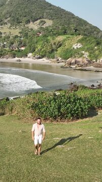 Ponta das Campanhas, Armacao in Florianopolis. A man walks across the island among the rocks. Aerial view.