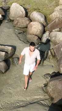 Ponta das Campanhas, Armacao in Florianopolis. A man walks across the island among the rocks. Aerial view.