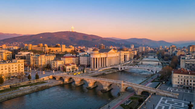 Aerial view of Skopje city center with the Stone Bridge and Vardar River at sunset.