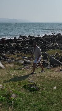 Ponta das Campanhas, Armacao in Florianopolis. A man walks across the island among the rocks. Aerial view.