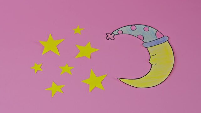 Stop Motion Animation Of Yellow Stars Appearing Next To Sleeping Paper Moon Character On Pink Background