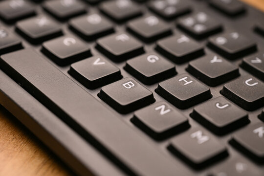 Side Angled Top View Macro Close-Up Black Computer Keyboard Highlighting B Key on Blurred Tech Background