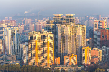 Obraz premium Panoramic view of Pyongyang from Yanggakdo Hotel. Taedong River in morning fog. Ryugyong Hotel and modern residential complex upstream. Atmospheric, calm, iconic. Pyongyang, North Korea