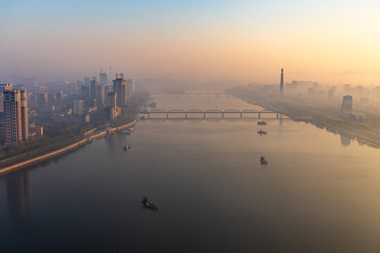 Juche Tower, Pyongyang morning panoramic view, North Korea. Taedong River in the morning fog. View facing upstream, modern residential complex. View from Yanggakdo Hotel