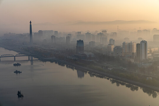 Juche Tower, Pyongyang morning panoramic view, North Korea. Taedong River in the morning fog. View facing upstream, modern residential complex. View from Yanggakdo Hotel