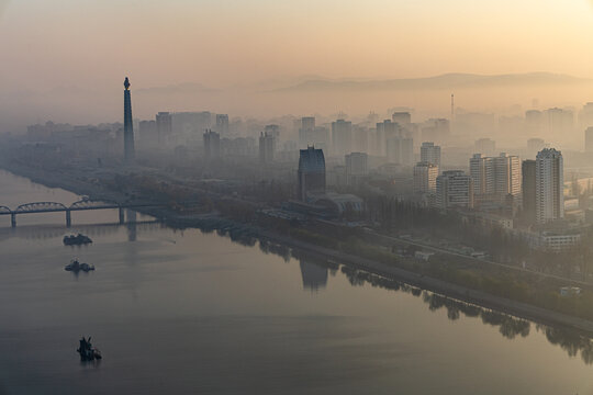 Juche Tower, Pyongyang morning panoramic view, North Korea. Taedong River in the morning fog. View facing upstream, modern residential complex. View from Yanggakdo Hotel