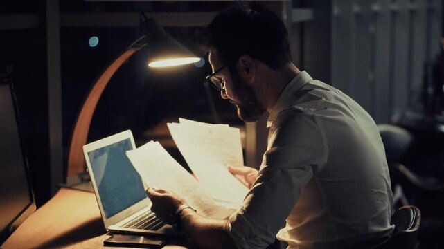 Businessman Working Late in Dark Office. Night Shift in Modern Company Office