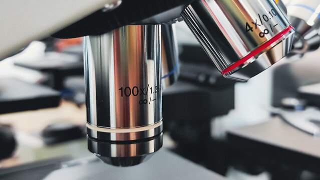 a close up view of a laboratory microscope with a white background and lab.