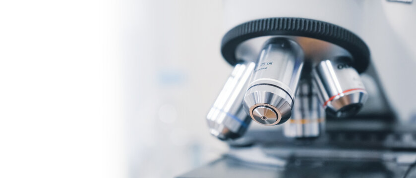a close up view of a laboratory microscope with a white background and lab.