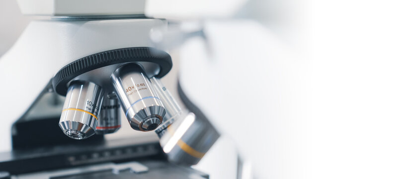 a close up view of a laboratory microscope with a white background and lab.