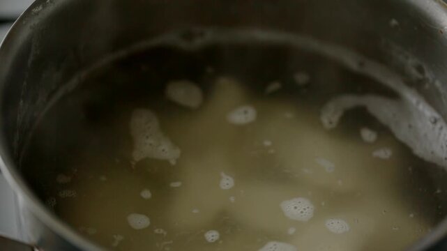 Potato dumplings are thrown into a pot of boiling water to cook