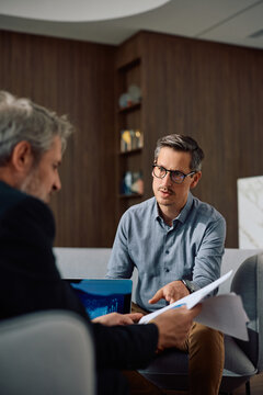 Business colleagues talking while working reports in office.