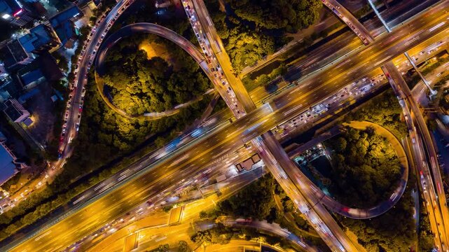 Expansive night hyperlapse showing the fast-paced flow of a massive urban highway network.