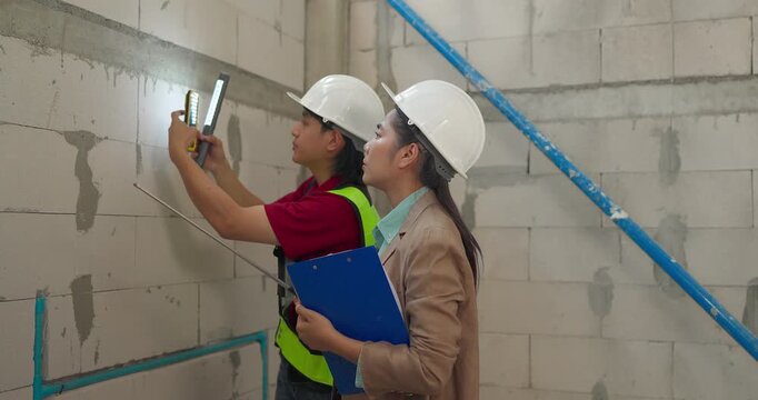 Site Engineer and Interior Designer Measure Wall Alignment During Renovation