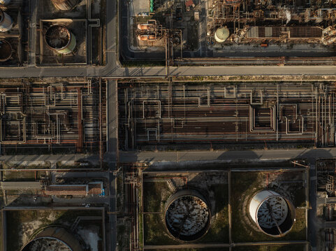 Aerial view of the intricate network of pipes and large storage tanks at an industrial refinery complex Priolo Gargallo, Sicily, Italy.