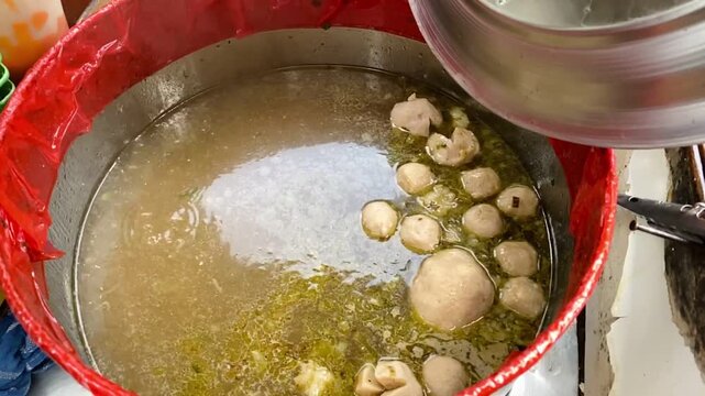 Meatballs with traditional Indonesian broth in a large pot