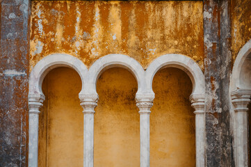Obraz premium Weathered yellow wall with decorative arches at Pena Palace, Sintra