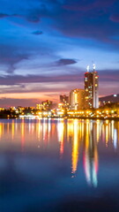 Obraz premium Blurred Cityscape Lights Reflecting on Lake Water at Night