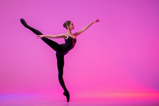 Silhouette of  ballet dancer in  black leotard in an arabesque pose