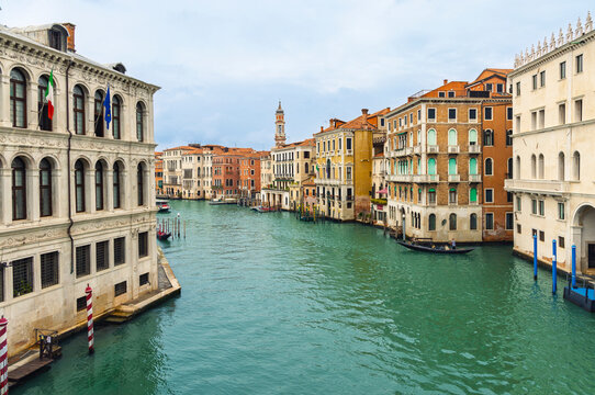 Panoramic view of the Grand Canal in Venice Italy with historical palaces gondolas and italian flag. travel destination, tour tourism in Italy, Europe