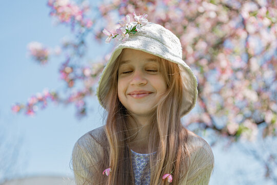 Happy girl in white sun hat enjoying spring sun