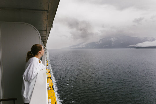 Girl on cruise ship balcony looking at view of pacific ocean