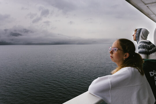 Teen siblings on balcony of cruise ship on stormy day in pacific