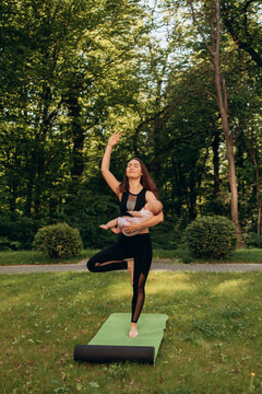 Active mother practicing yoga with child outdoors
