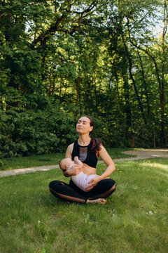 Mother feeding baby while meditating outdoors in park