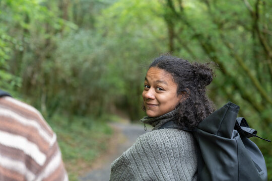 Woman hiking in nature smiling looking back
