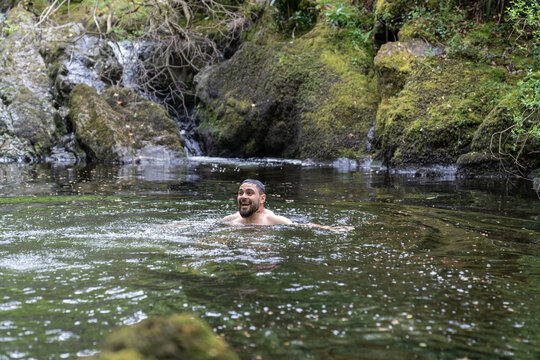 Man swimming in a refreshing clear forest lake