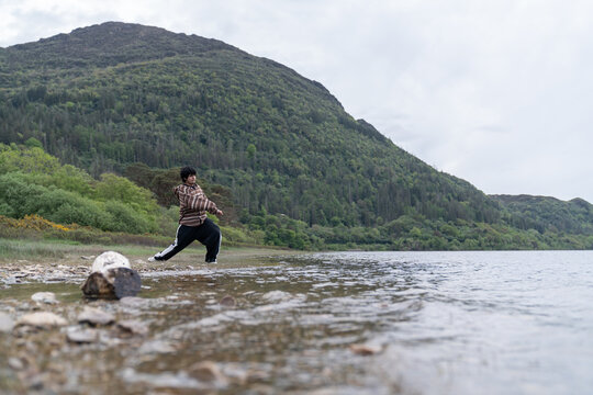Person stretching performing a lunge pose in nature