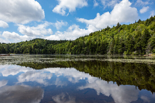 Blue sky and clouds reflected in tranquil Lake Solitude