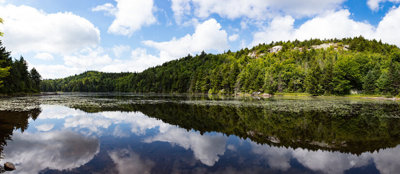 Summer day clouds reflecting in a still mountain lake