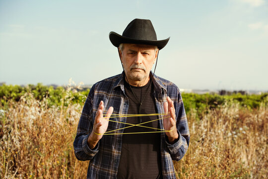 Man playing cat&rsquo;s cradle outdoors