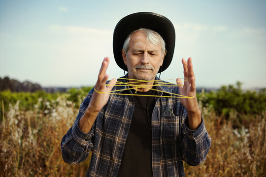 Happy man with yellow thread in countryside field