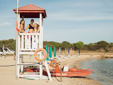 Rescue Boat and Lifeguard Tower with Three Women at Beach