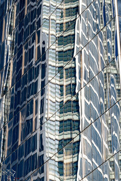 A reflective glass tower in Lyon turns office architecture into an abstract facade, with windows and vertical lines rippling across the frame