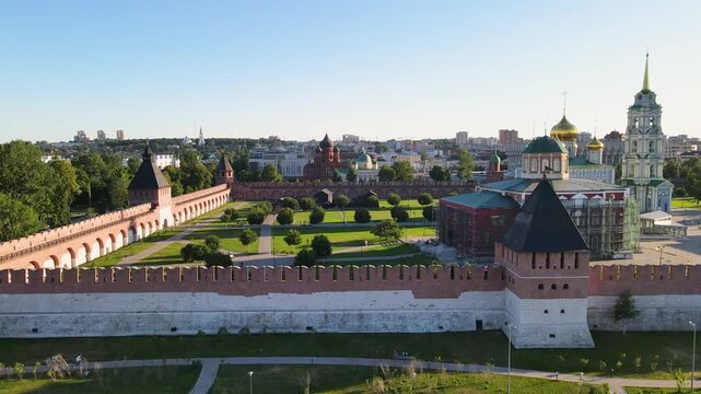Aerial sideways tracking shot of the Tula Kremlin fortress walls and towers. Panoramic view featuring the Assumption Cathedral and city skyline under a clear blue sky in Russia