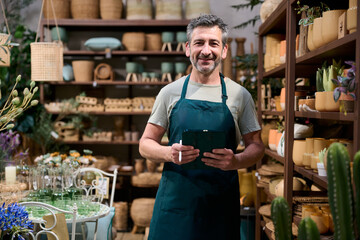 Fototapeta na wymiar Small business owner man managing plant shop with tablet